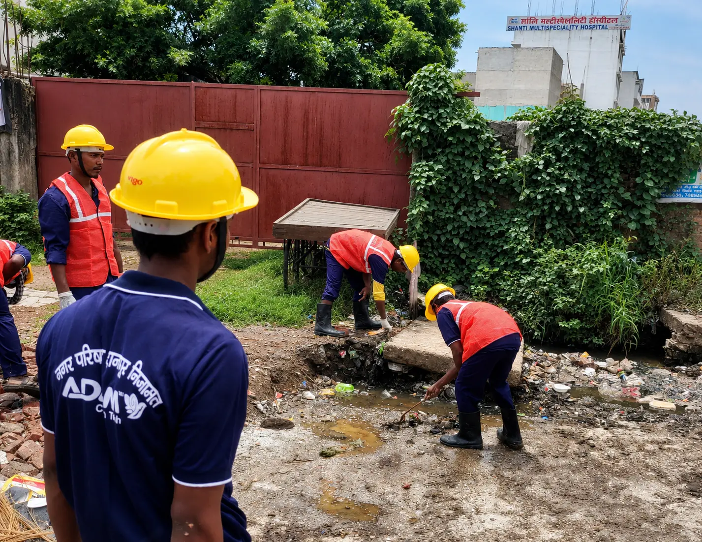 Municipal sanitation team and mechanised road sweeper at work